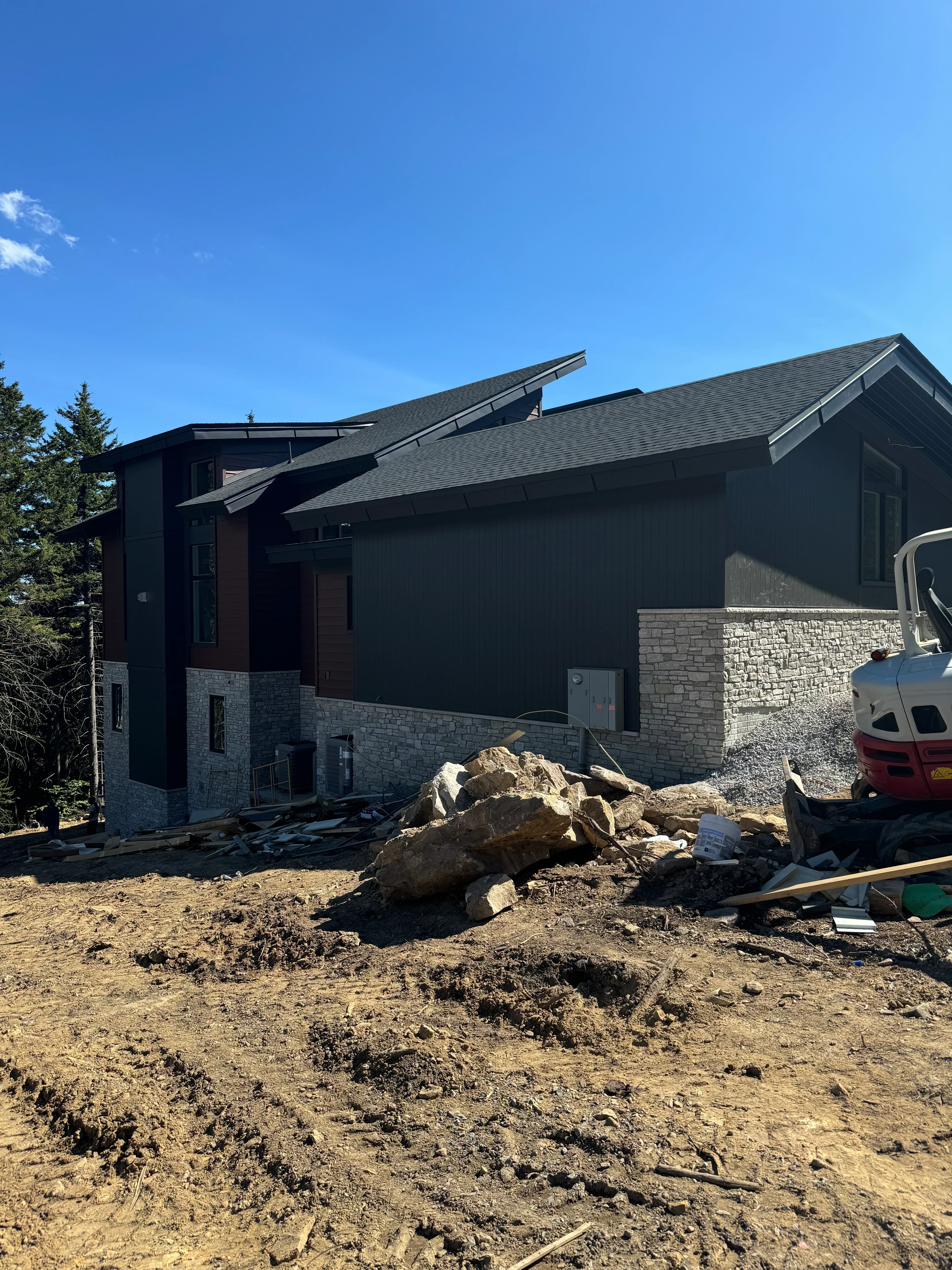 Dark asphalt shingle roof installation on residential home with proper flashing and edge details